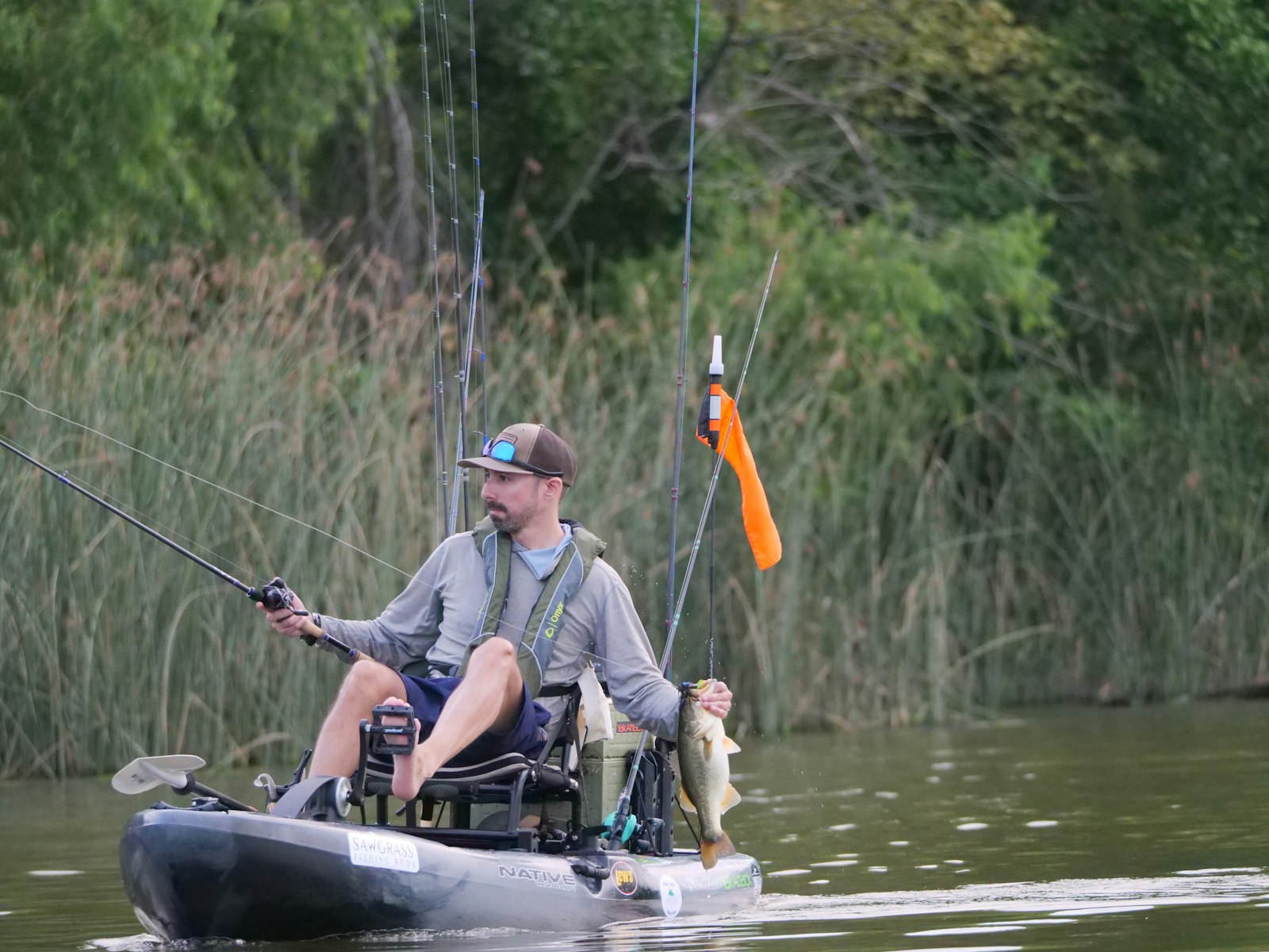 A kayak angler holding a bass
